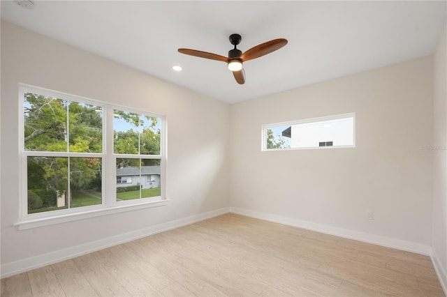 spare room featuring plenty of natural light, light wood-style flooring, and baseboards