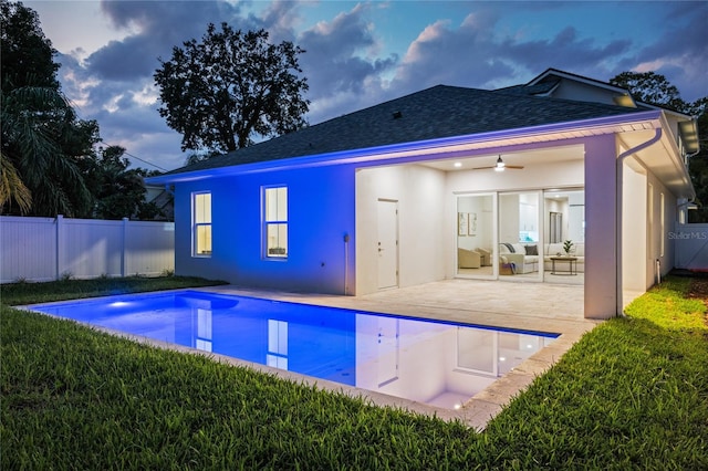 back of house featuring a lawn, a patio, a fenced backyard, roof with shingles, and a fenced in pool