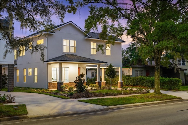 view of front of home featuring brick siding and stucco siding