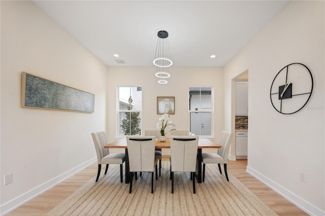 dining room with recessed lighting, light wood-style flooring, and baseboards