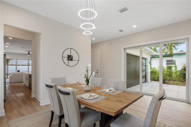 dining area with light wood-type flooring, visible vents, a notable chandelier, recessed lighting, and baseboards