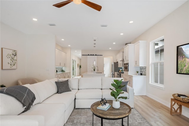 living area featuring light wood-style flooring, recessed lighting, and visible vents