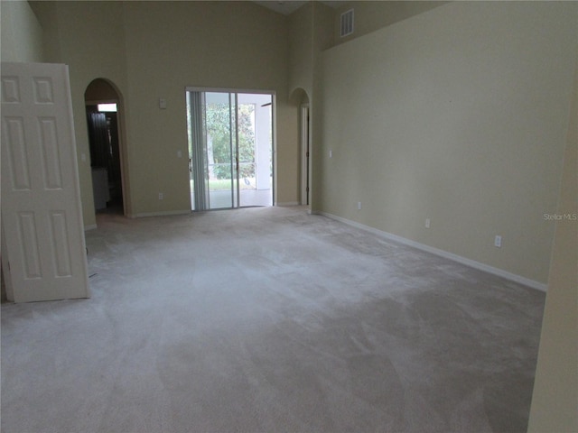 carpeted empty room with a high ceiling