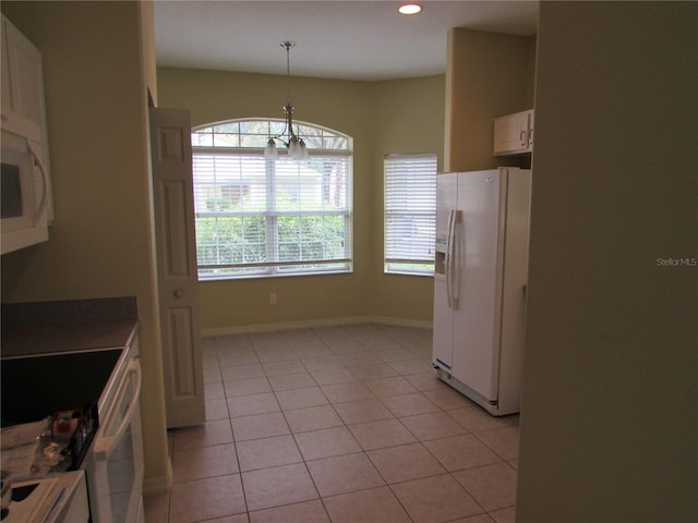 kitchen with white cabinets, light tile patterned flooring, pendant lighting, and white appliances