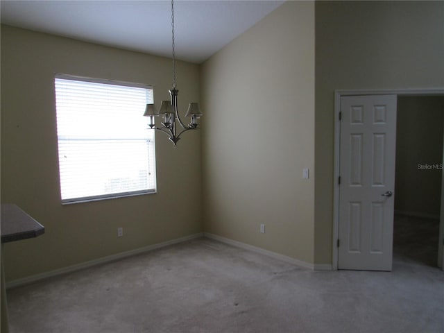 unfurnished dining area featuring carpet flooring and a chandelier