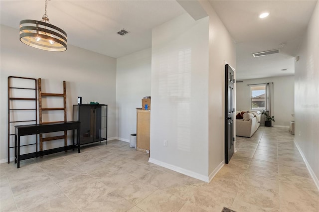 hall with light tile patterned floors and an inviting chandelier