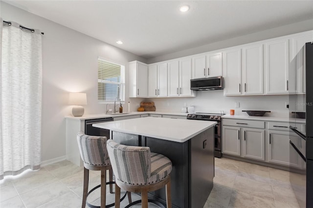 kitchen with sink, a kitchen island, a kitchen breakfast bar, white cabinetry, and stainless steel appliances