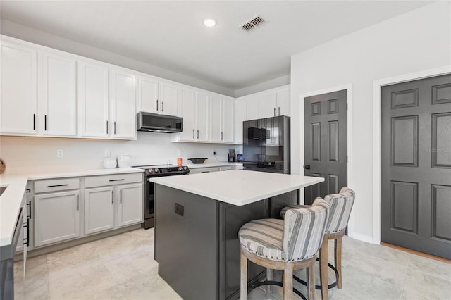 kitchen featuring a center island, a kitchen bar, stainless steel appliances, and white cabinets