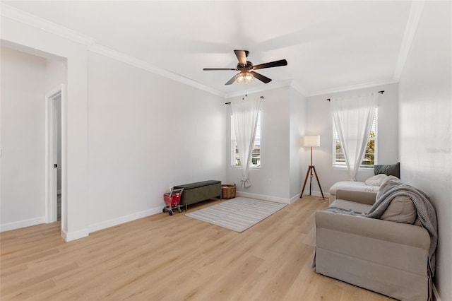 living room featuring ceiling fan, ornamental molding, and light hardwood / wood-style flooring