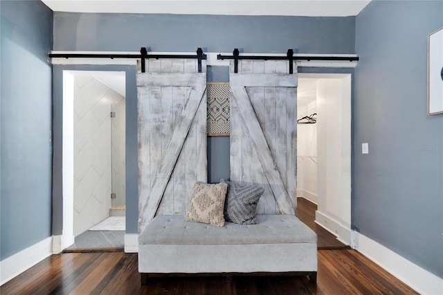 sitting room with dark wood-type flooring and a barn door