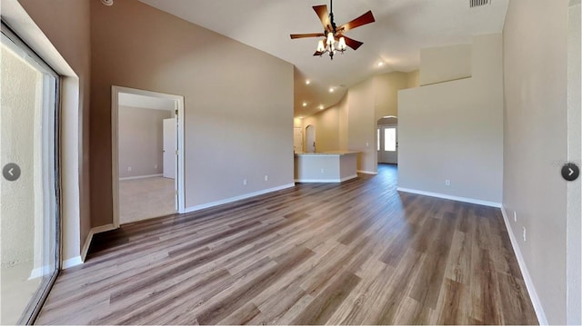 unfurnished living room featuring light hardwood / wood-style flooring, high vaulted ceiling, and ceiling fan