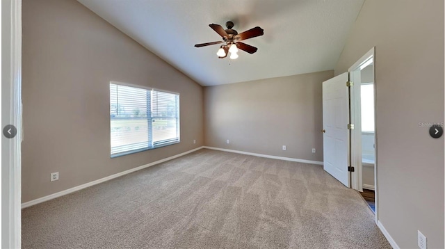 spare room with vaulted ceiling, light carpet, and ceiling fan