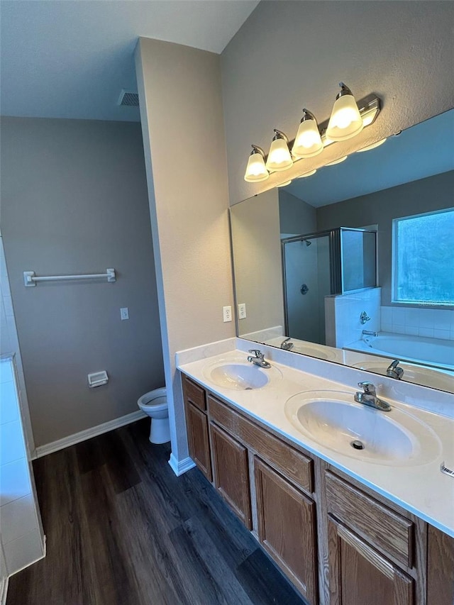 full bathroom with toilet, independent shower and bath, hardwood / wood-style floors, vaulted ceiling, and vanity