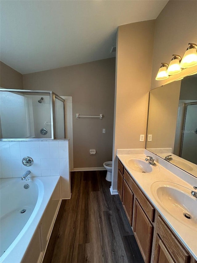 full bathroom with hardwood / wood-style flooring, toilet, vaulted ceiling, vanity, and shower with separate bathtub