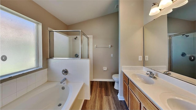 full bathroom featuring hardwood / wood-style floors, shower with separate bathtub, vaulted ceiling, toilet, and vanity