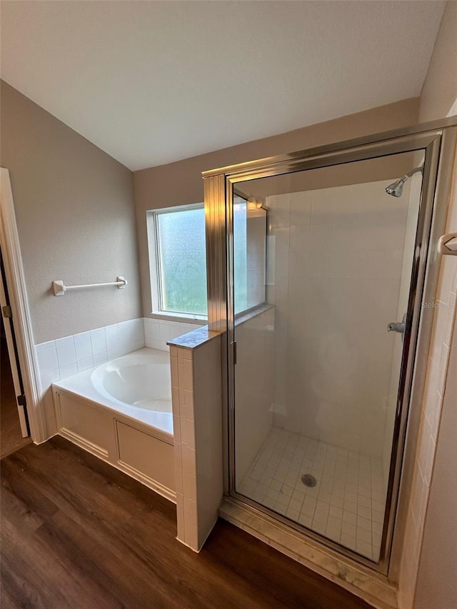 bathroom featuring wood-type flooring and shower with separate bathtub