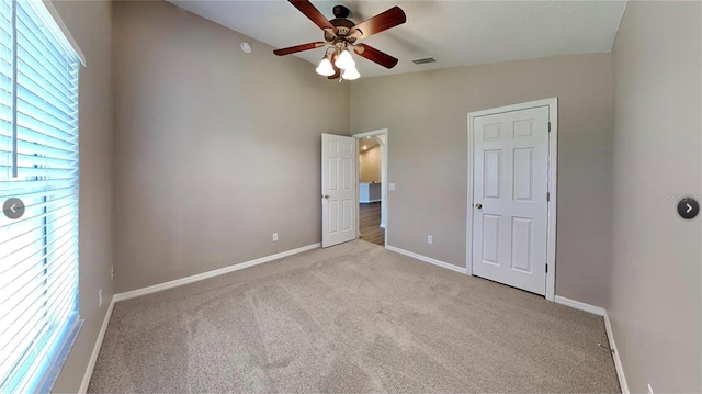 unfurnished bedroom with ceiling fan, light carpet, and vaulted ceiling