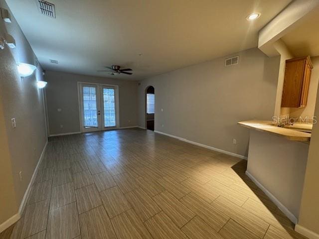 unfurnished living room with french doors, hardwood / wood-style flooring, and ceiling fan