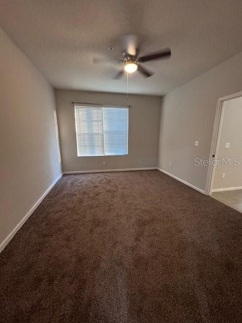 carpeted spare room featuring ceiling fan