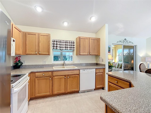 kitchen with white appliances, light tile patterned floors, and sink