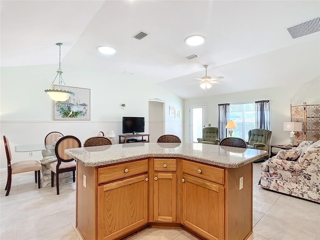 kitchen with lofted ceiling, ceiling fan, decorative light fixtures, and a kitchen island