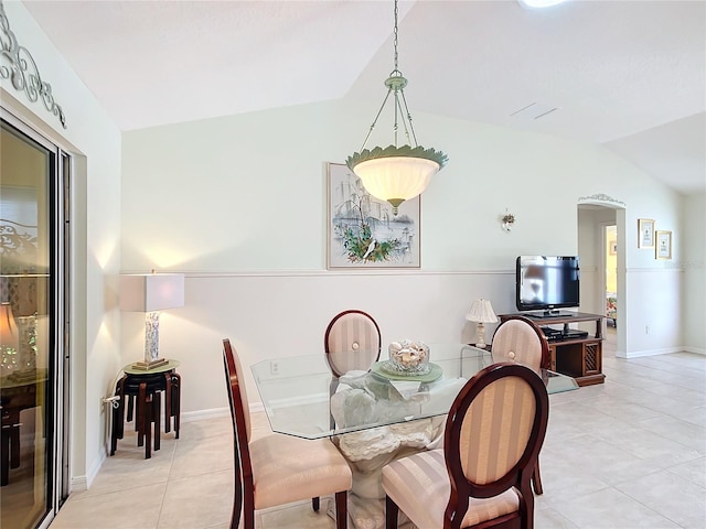 tiled dining area featuring vaulted ceiling