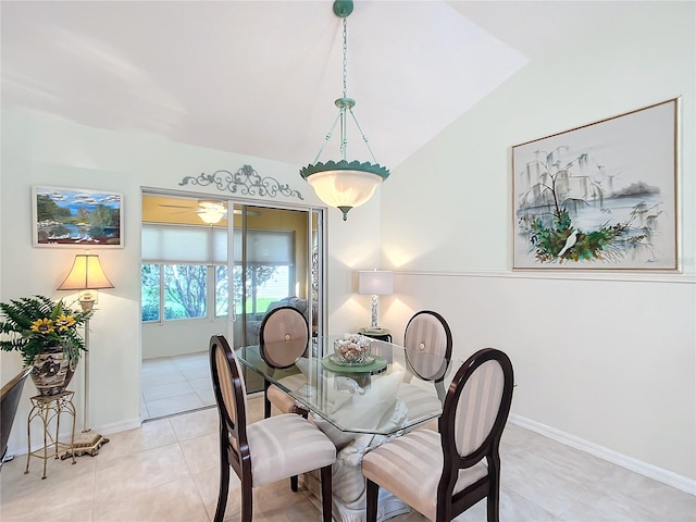 tiled dining space featuring ceiling fan and lofted ceiling