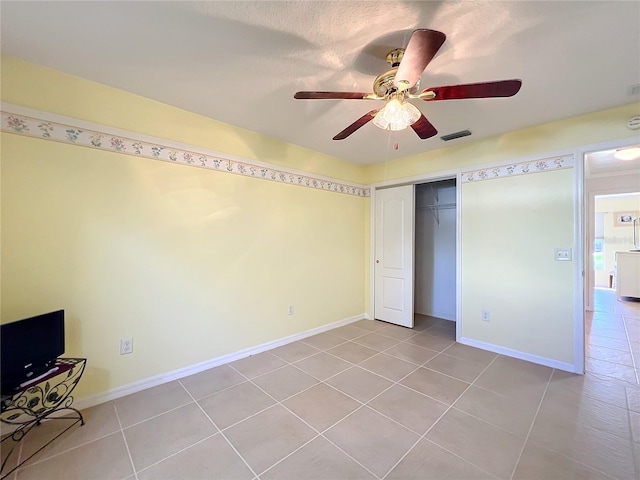 unfurnished bedroom with a closet, ceiling fan, and light tile patterned flooring