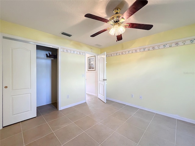 unfurnished bedroom with a closet, ceiling fan, and light tile patterned floors