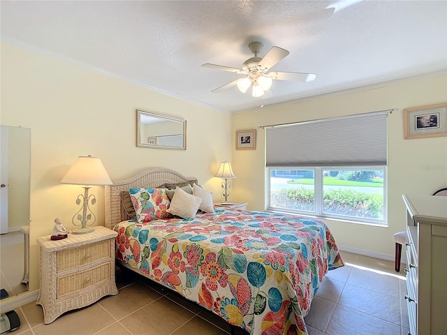 bedroom featuring ornamental molding, dark tile patterned flooring, and ceiling fan