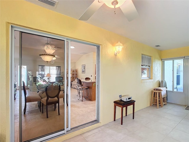 interior space with a wealth of natural light, vaulted ceiling, and ceiling fan