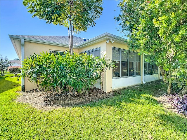 view of property exterior featuring a yard and a sunroom