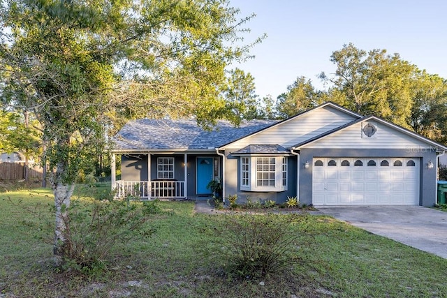 ranch-style home with covered porch, a front yard, and a garage