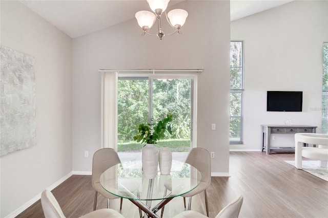 dining room featuring lofted ceiling, a notable chandelier, and wood-type flooring