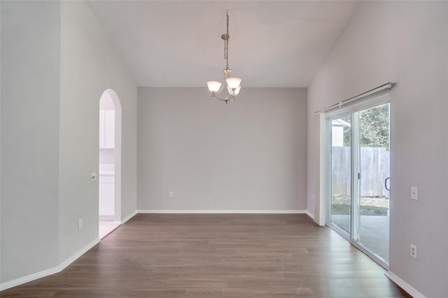 unfurnished room featuring hardwood / wood-style flooring and a chandelier