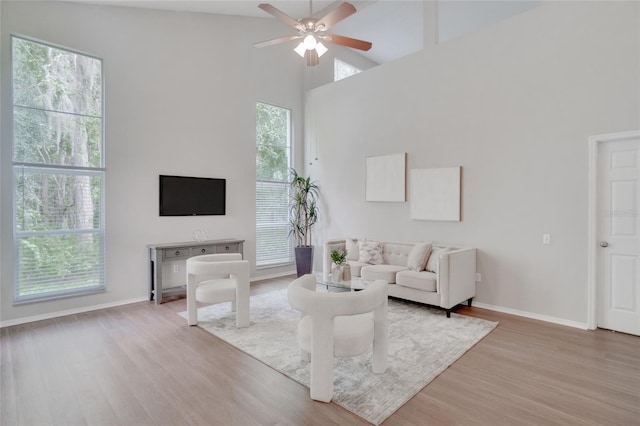 living room with a wealth of natural light, light hardwood / wood-style flooring, and high vaulted ceiling