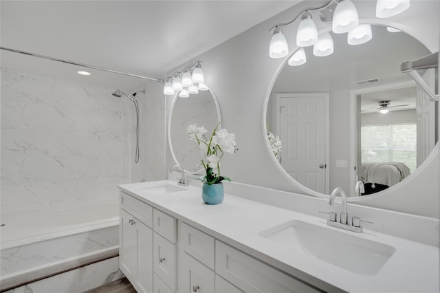 bathroom featuring vanity, ceiling fan, and tiled shower / bath combo