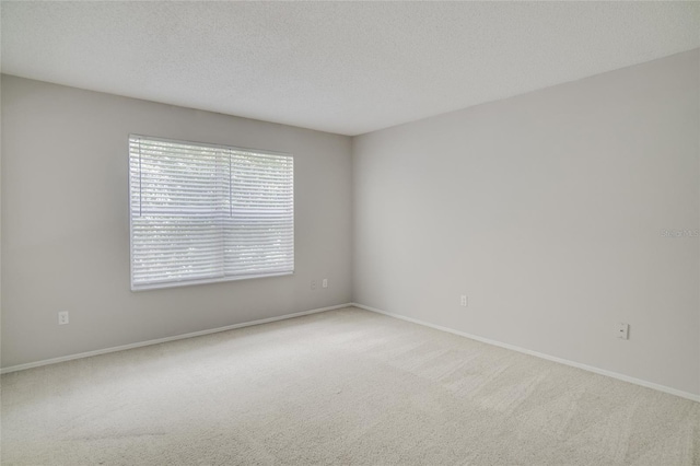 carpeted empty room featuring a textured ceiling