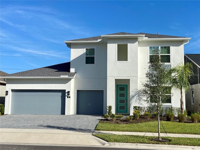 58 Overleaf Ln, Orlando, FL 32839 - view of front of house with stucco siding, decorative driveway, roof with shingles, and a garage