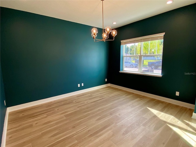 unfurnished room featuring light hardwood / wood-style flooring and a chandelier