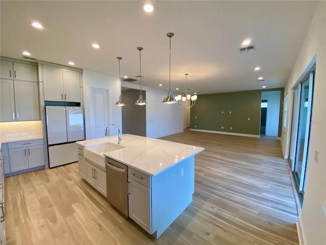 kitchen featuring a center island with sink, dishwasher, light hardwood / wood-style flooring, and white refrigerator