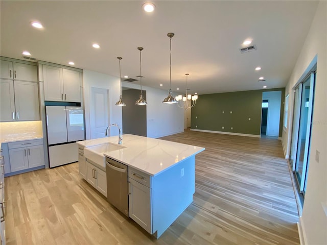 58 Overleaf Ln, Orlando, FL 32839 - kitchen featuring white refrigerator, stainless steel dishwasher, a sink, light wood-style flooring, and light stone counters