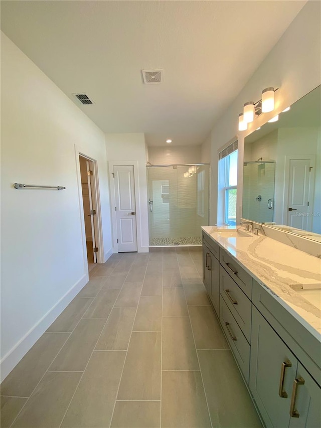 bathroom featuring vanity, a shower with shower door, and tile patterned floors