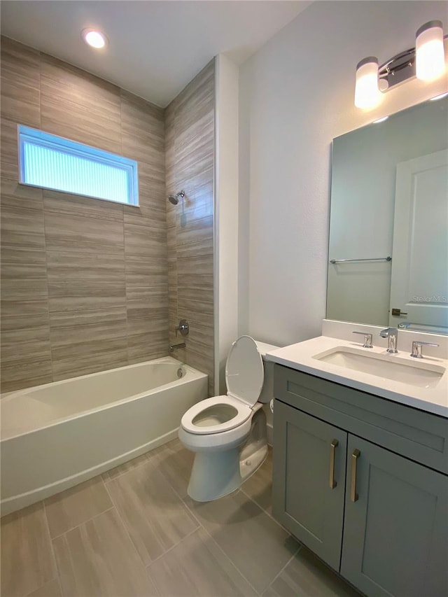 full bathroom featuring toilet, tiled shower / bath combo, vanity, and tile patterned floors