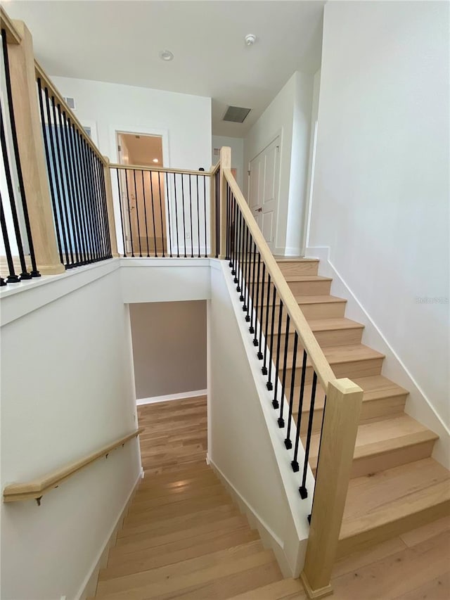 stairway with hardwood / wood-style flooring