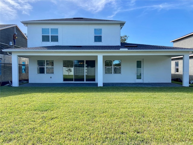 rear view of house featuring a yard and a patio