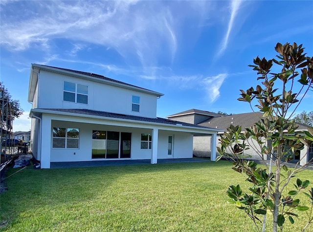 rear view of house featuring a yard