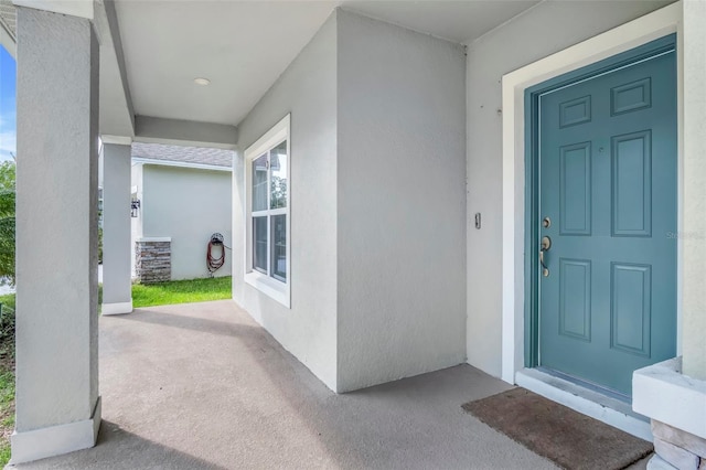 view of exterior entry featuring covered porch