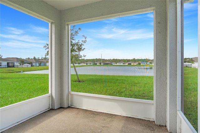 unfurnished sunroom featuring a water view