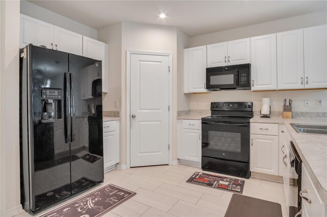 kitchen featuring white cabinets and black appliances